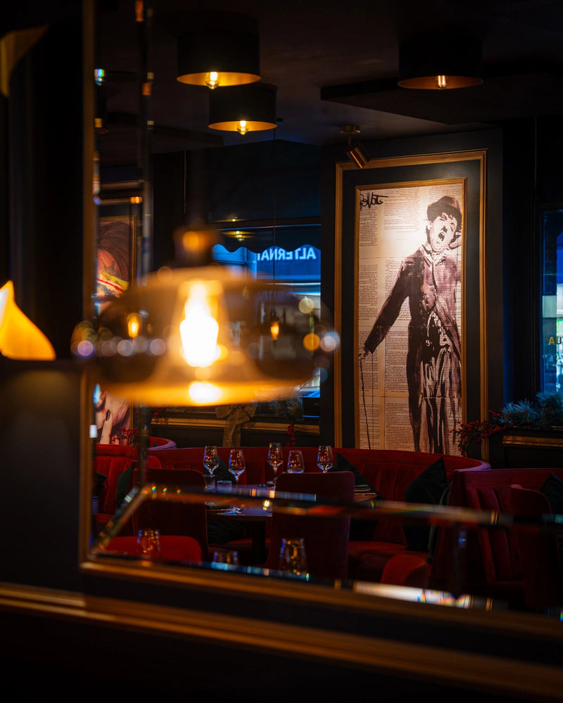 Red velvet booth seating and wall art at LOSH Bar & Grill, Harpenden